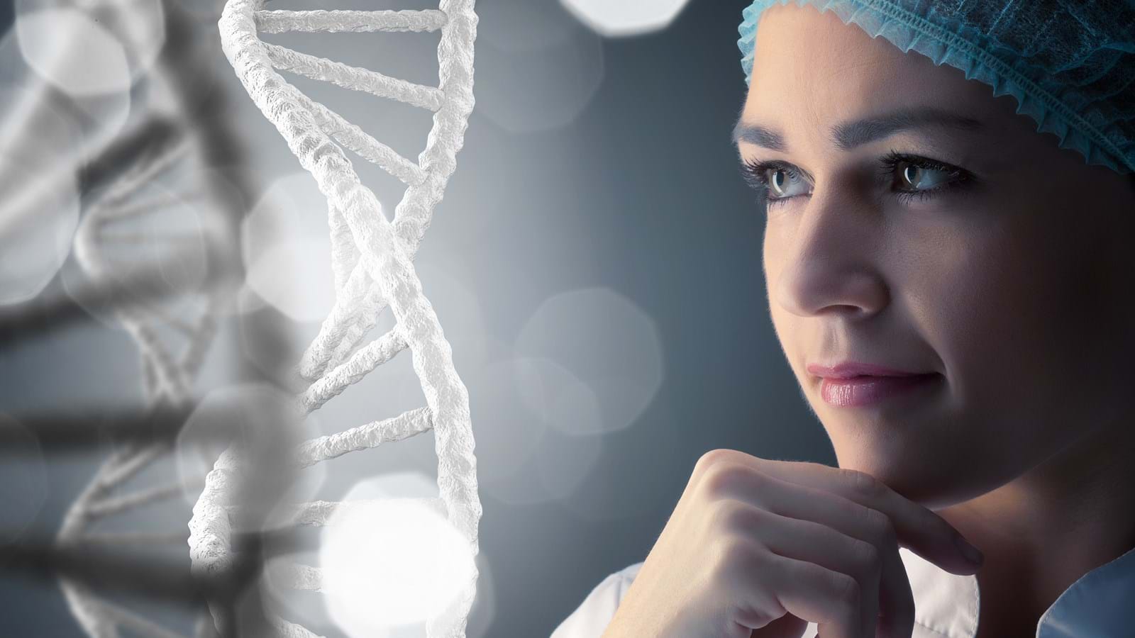 Kvinne i laboratorieutstyr som ser på en DNA-struktur.