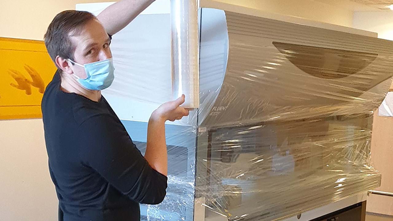 Produktsjef Kristian Wittek pakker pipetteringsroboten i plast og demonteres.